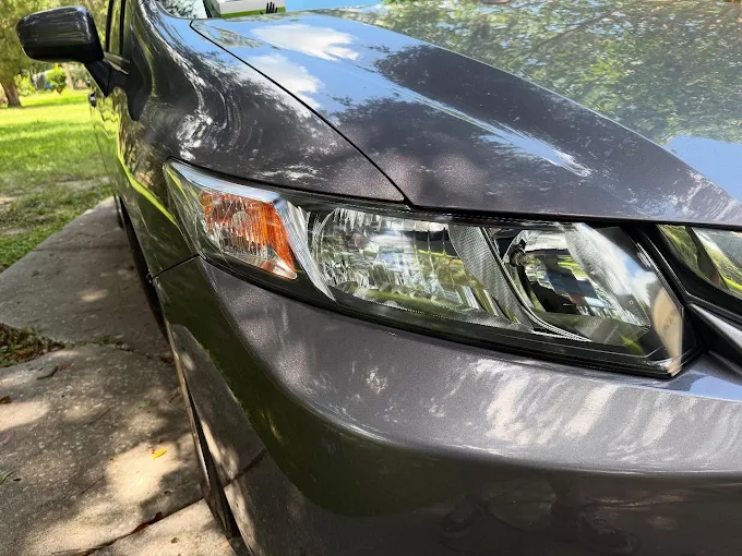 Clear restored headlight on a gray Honda Civic after headlight restoration
